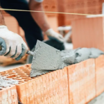 maçon en train de monter des briques mono-murs