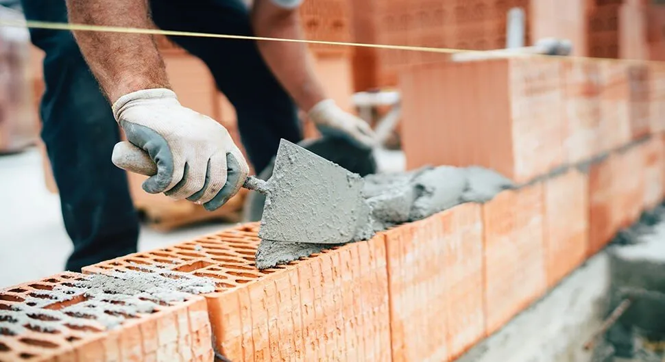 maçon en train de monter des briques mono-murs